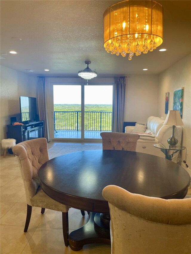 dining area featuring light tile patterned floors and a textured ceiling