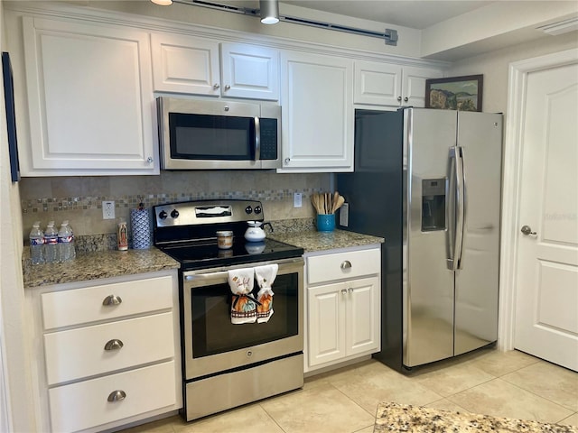 kitchen with white cabinets, appliances with stainless steel finishes, tasteful backsplash, and stone countertops