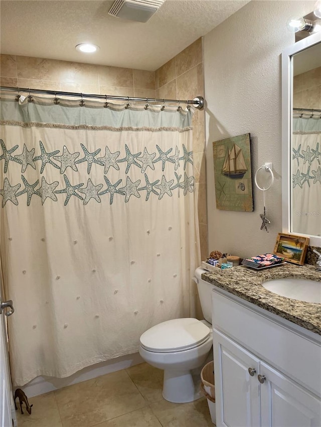 bathroom featuring vanity, tile patterned floors, toilet, a textured ceiling, and curtained shower