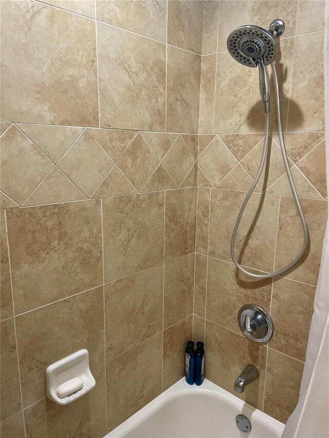 interior details featuring shower / bathtub combination with curtain