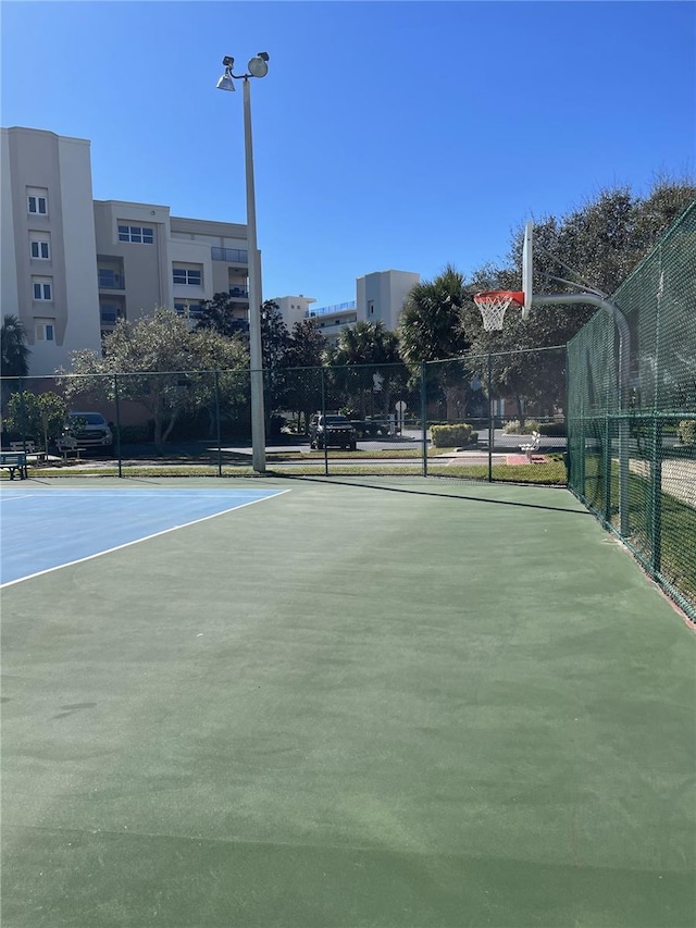 view of tennis court with basketball hoop