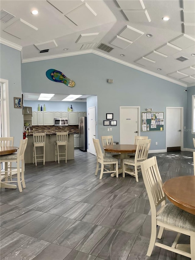 dining area with vaulted ceiling and ornamental molding