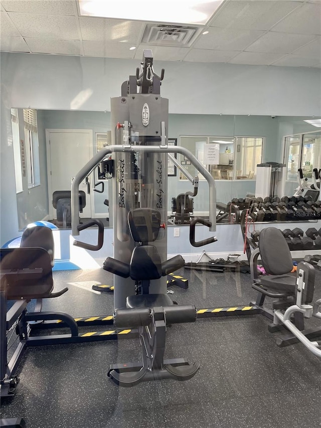 exercise room with a drop ceiling and plenty of natural light