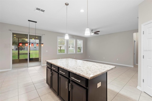 kitchen featuring hanging light fixtures, light tile patterned floors, a kitchen island, and ceiling fan