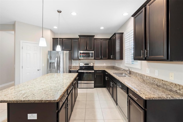 kitchen with sink, a kitchen island, decorative light fixtures, light tile patterned floors, and appliances with stainless steel finishes