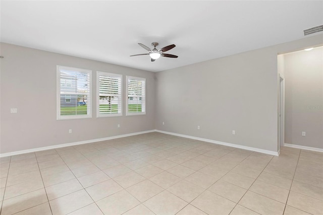 empty room with ceiling fan and light tile patterned floors