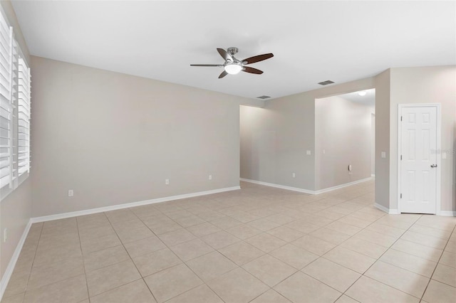 tiled empty room with a wealth of natural light and ceiling fan