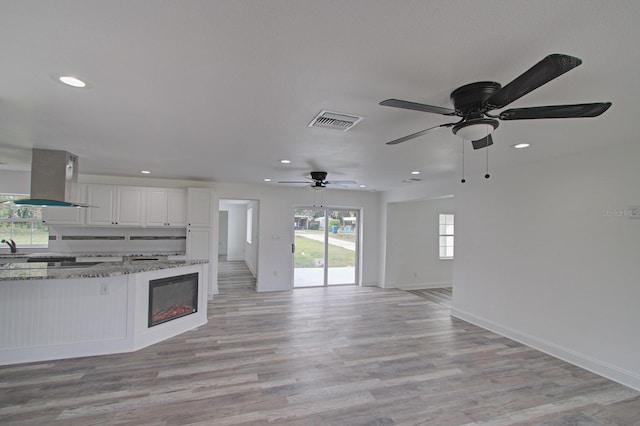 unfurnished living room with ceiling fan and light hardwood / wood-style flooring