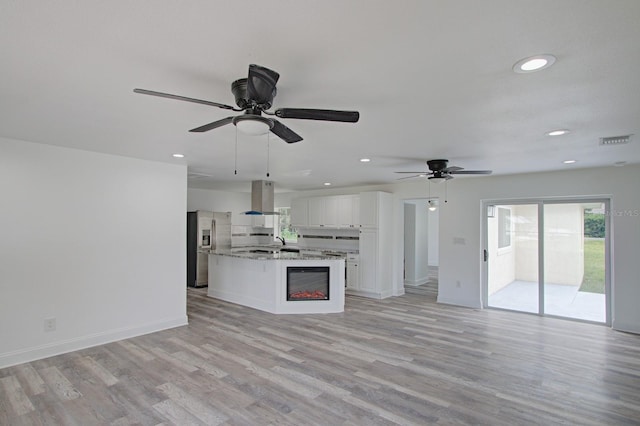 unfurnished living room featuring ceiling fan, sink, and light wood-type flooring