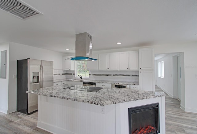 kitchen with island exhaust hood, white cabinetry, a center island, and stainless steel appliances