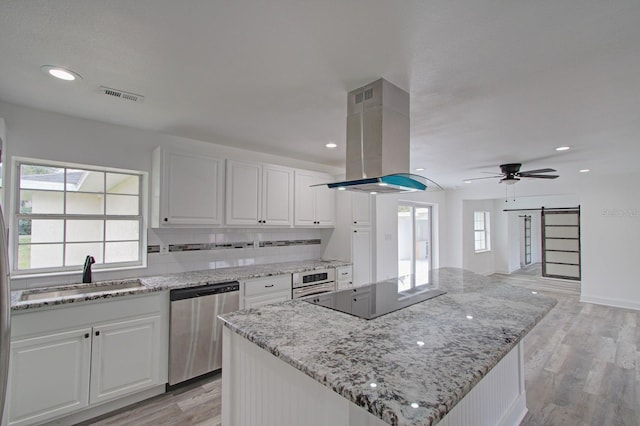 kitchen featuring appliances with stainless steel finishes, island range hood, sink, white cabinets, and light hardwood / wood-style floors