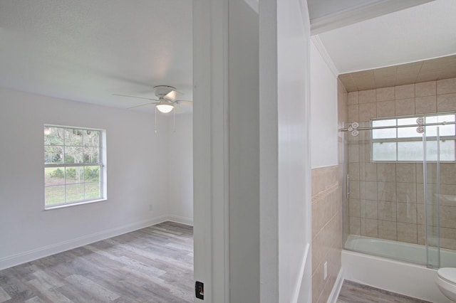 bathroom featuring hardwood / wood-style floors, toilet, ceiling fan, and combined bath / shower with glass door