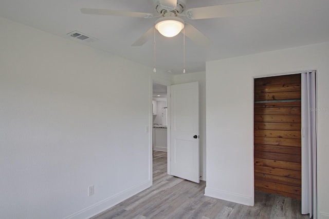 unfurnished bedroom featuring a closet, light hardwood / wood-style flooring, and ceiling fan