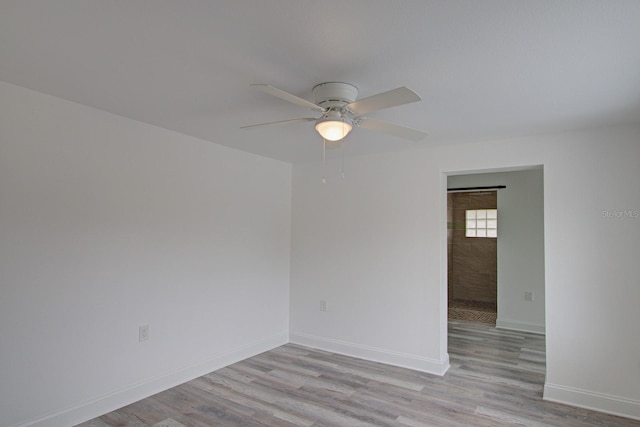 empty room with ceiling fan and light wood-type flooring