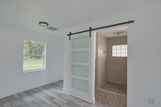 bathroom featuring tiled shower, hardwood / wood-style floors, and built in shelves