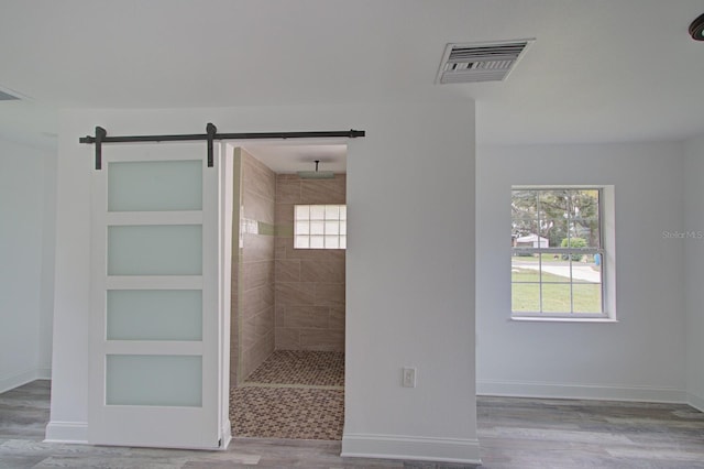 bathroom featuring hardwood / wood-style flooring, built in shelves, and tiled shower