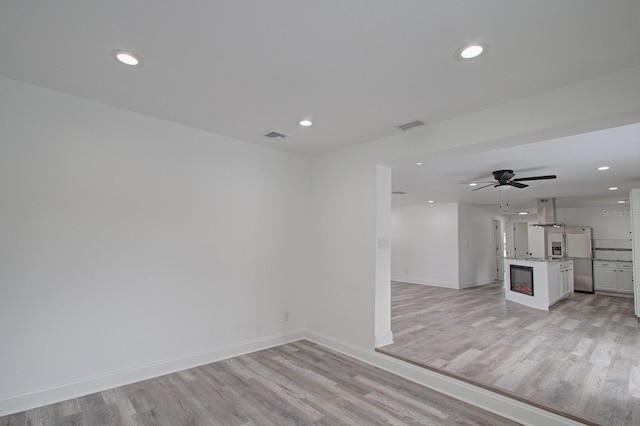 unfurnished room featuring light wood-type flooring and ceiling fan