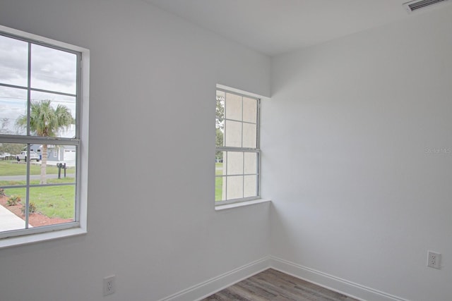 unfurnished room with plenty of natural light and hardwood / wood-style floors