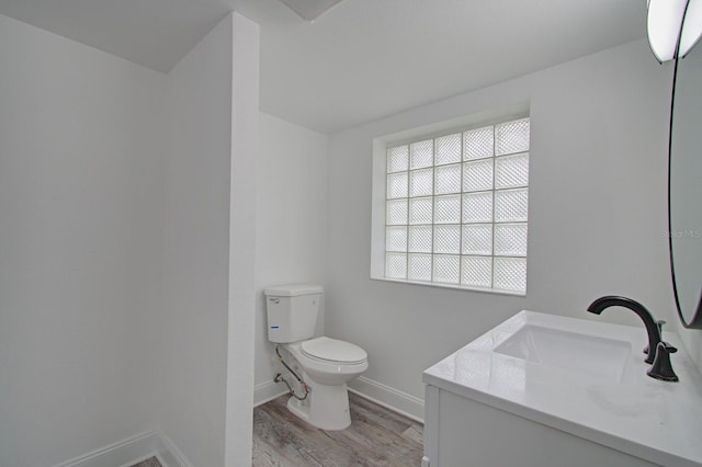 bathroom with hardwood / wood-style flooring, vanity, and toilet