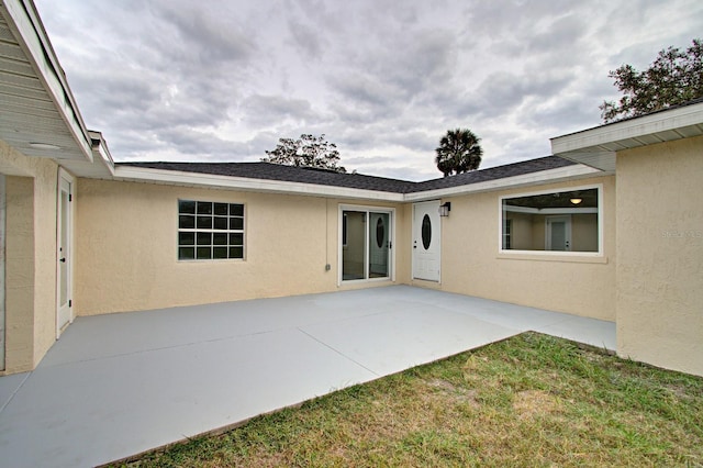 rear view of house featuring a yard and a patio