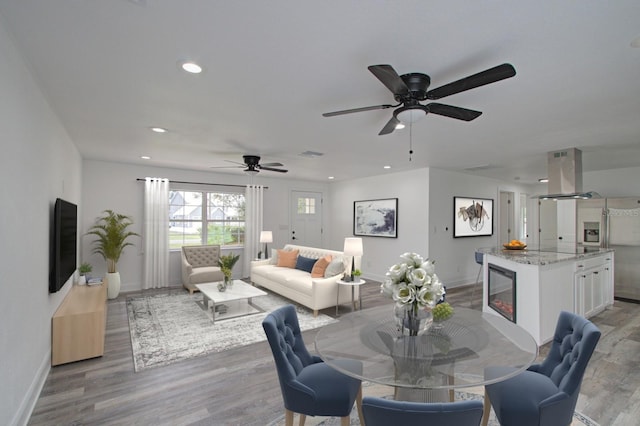 dining area with ceiling fan, wine cooler, and light hardwood / wood-style flooring