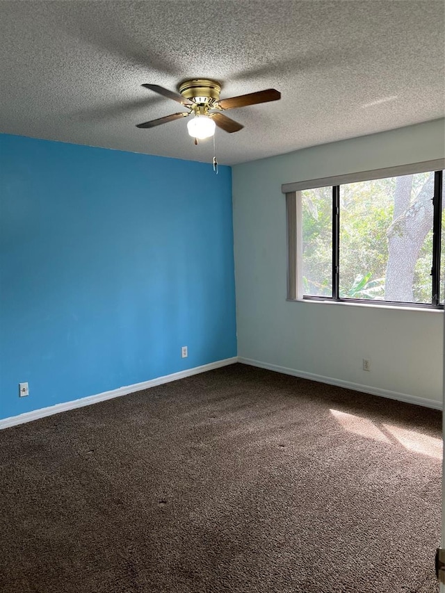 carpeted spare room featuring ceiling fan and a textured ceiling