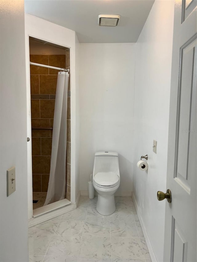 bathroom with curtained shower and toilet