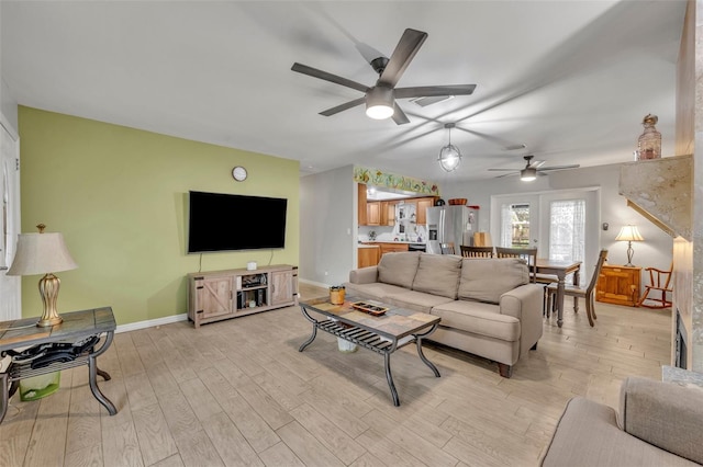 living room featuring ceiling fan and light hardwood / wood-style floors