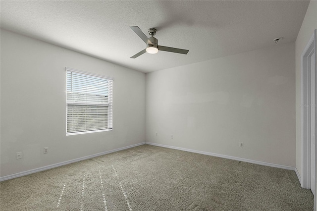 empty room with ceiling fan, carpet floors, and a textured ceiling