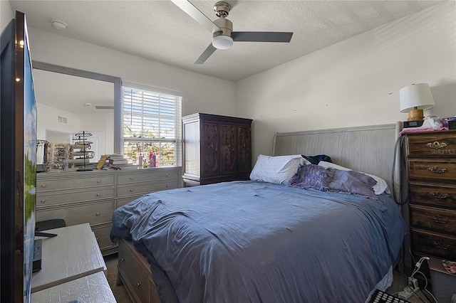 bedroom with a textured ceiling and ceiling fan