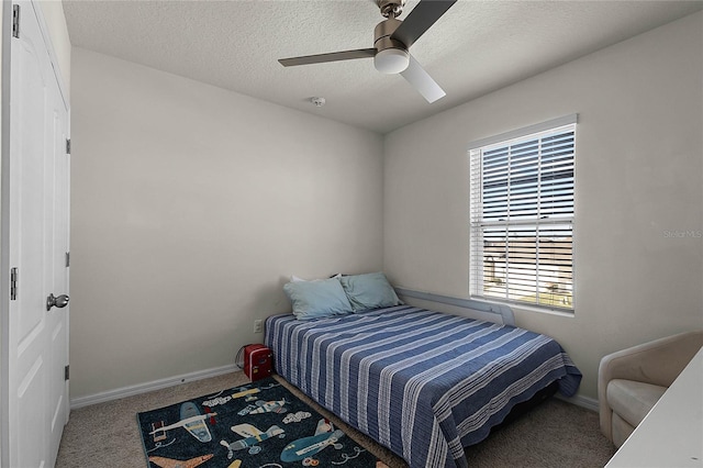 bedroom with carpet flooring, ceiling fan, and a textured ceiling