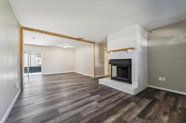 unfurnished living room with a fireplace and dark hardwood / wood-style floors