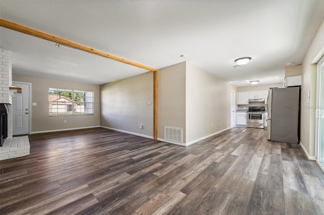 unfurnished living room with dark hardwood / wood-style floors and a fireplace