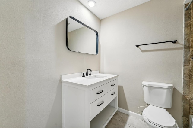 bathroom with toilet, vanity, and tile patterned floors