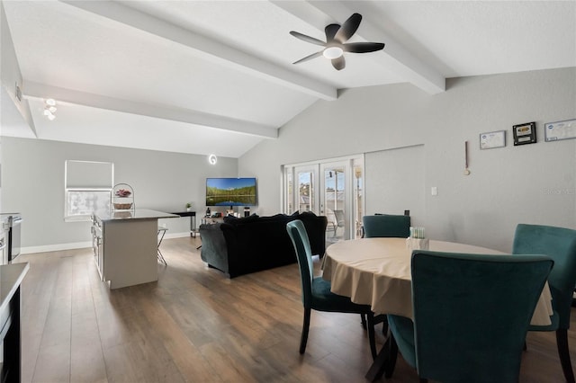 dining area featuring ceiling fan, lofted ceiling with beams, dark wood-type flooring, and a wealth of natural light