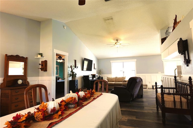 dining space with a textured ceiling, ceiling fan, lofted ceiling, and dark wood-type flooring