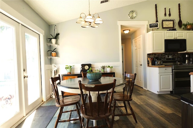 dining area featuring a chandelier, dark wood-type flooring, and vaulted ceiling