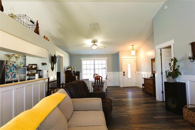 living room with ceiling fan and dark hardwood / wood-style flooring