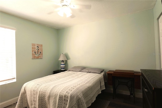 bedroom with multiple windows, ceiling fan, and dark hardwood / wood-style floors