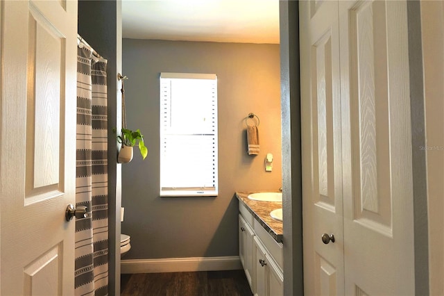 bathroom featuring hardwood / wood-style flooring, vanity, and toilet