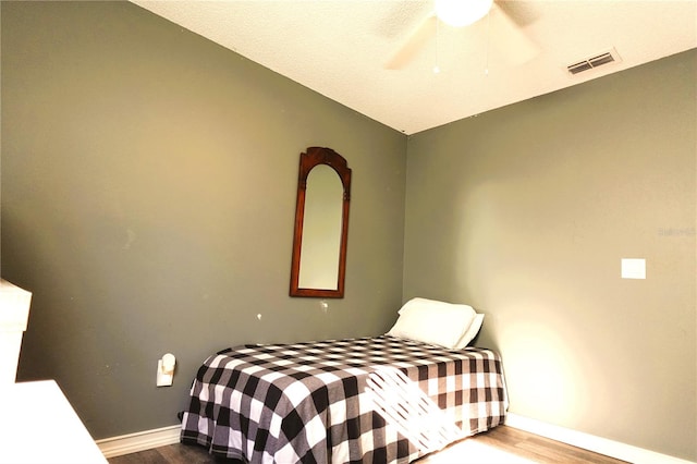 bedroom featuring hardwood / wood-style flooring, vaulted ceiling, and ceiling fan