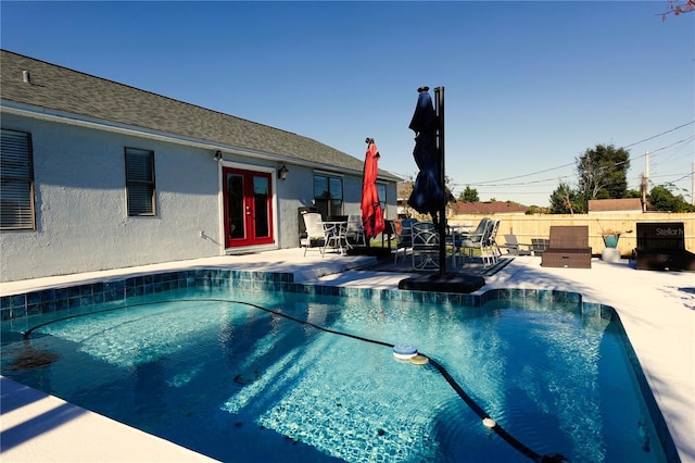 view of swimming pool with a patio and french doors