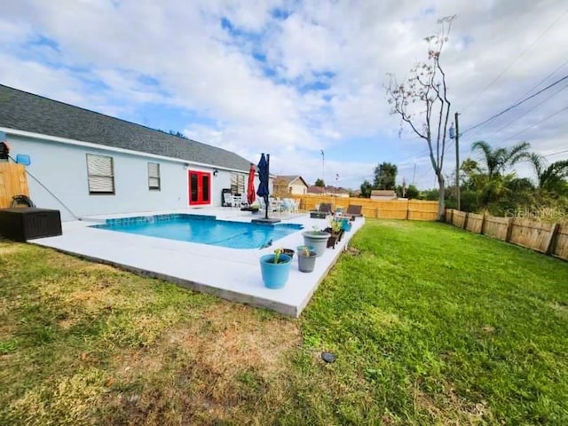 view of swimming pool with a yard