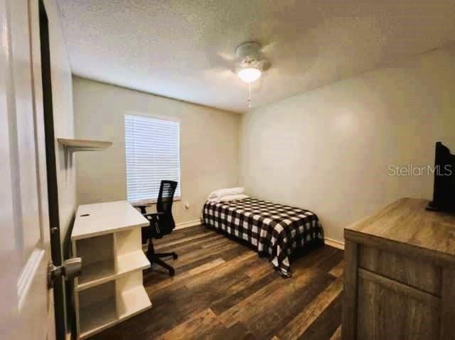 bedroom with ceiling fan and dark hardwood / wood-style flooring