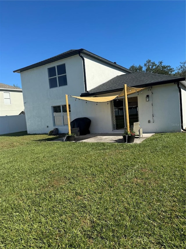 back of property with a patio area and a lawn