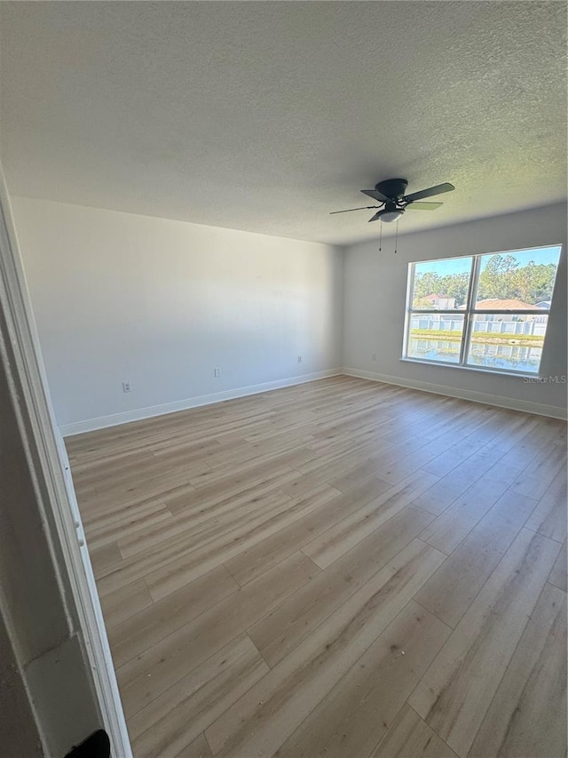 spare room featuring ceiling fan, a textured ceiling, and light wood-type flooring