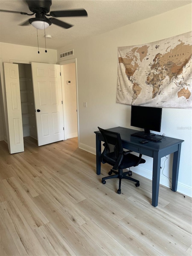 home office with ceiling fan and light hardwood / wood-style floors