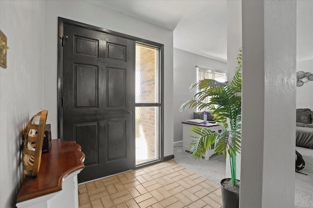 foyer entrance featuring light carpet and a wealth of natural light