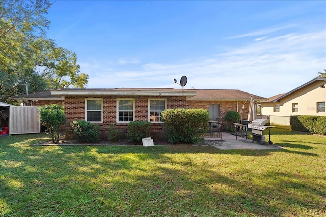 rear view of house featuring a lawn and a patio