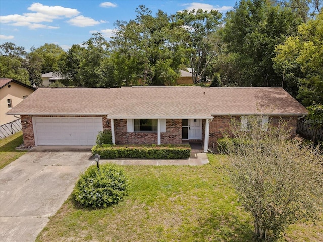 view of front facade with a garage, a front yard, concrete driveway, and brick siding